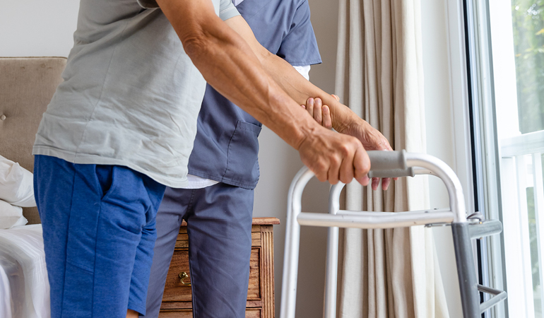 A senior resident performing hand exercises with an occupational therapist in a specialized Stroke rehabilitation senior living near Delhi facility.